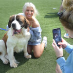 girl takes picture of dog with girl